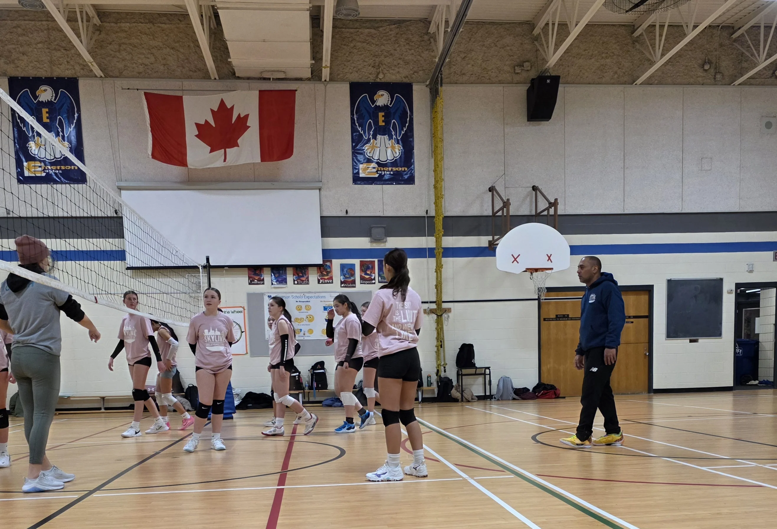 Volleyball coaches and volunteers supporting athletes at a Sky Volleyball program