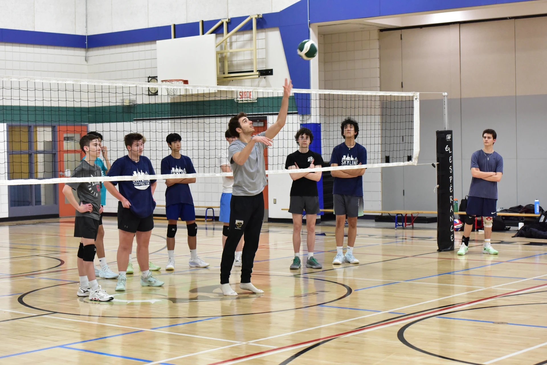 Coach addressing volleyball team during training session